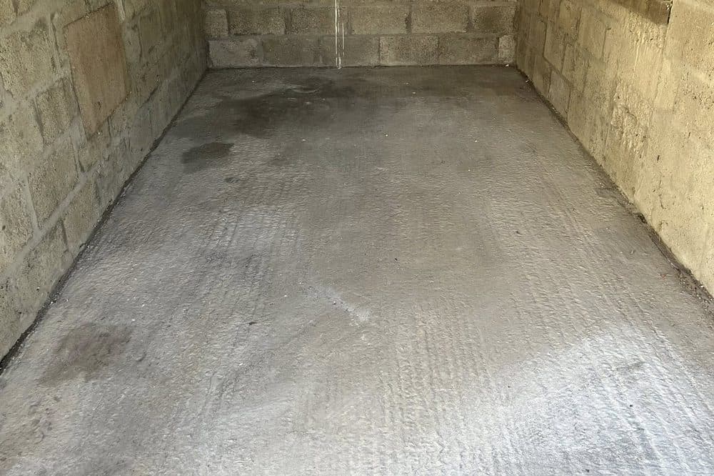 After: same garage cleared back to bare block walls and clean concrete floor, ready for handover